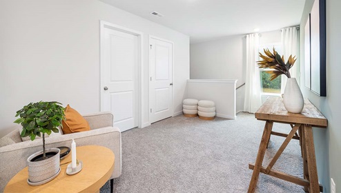 Carpeted loft space with large window