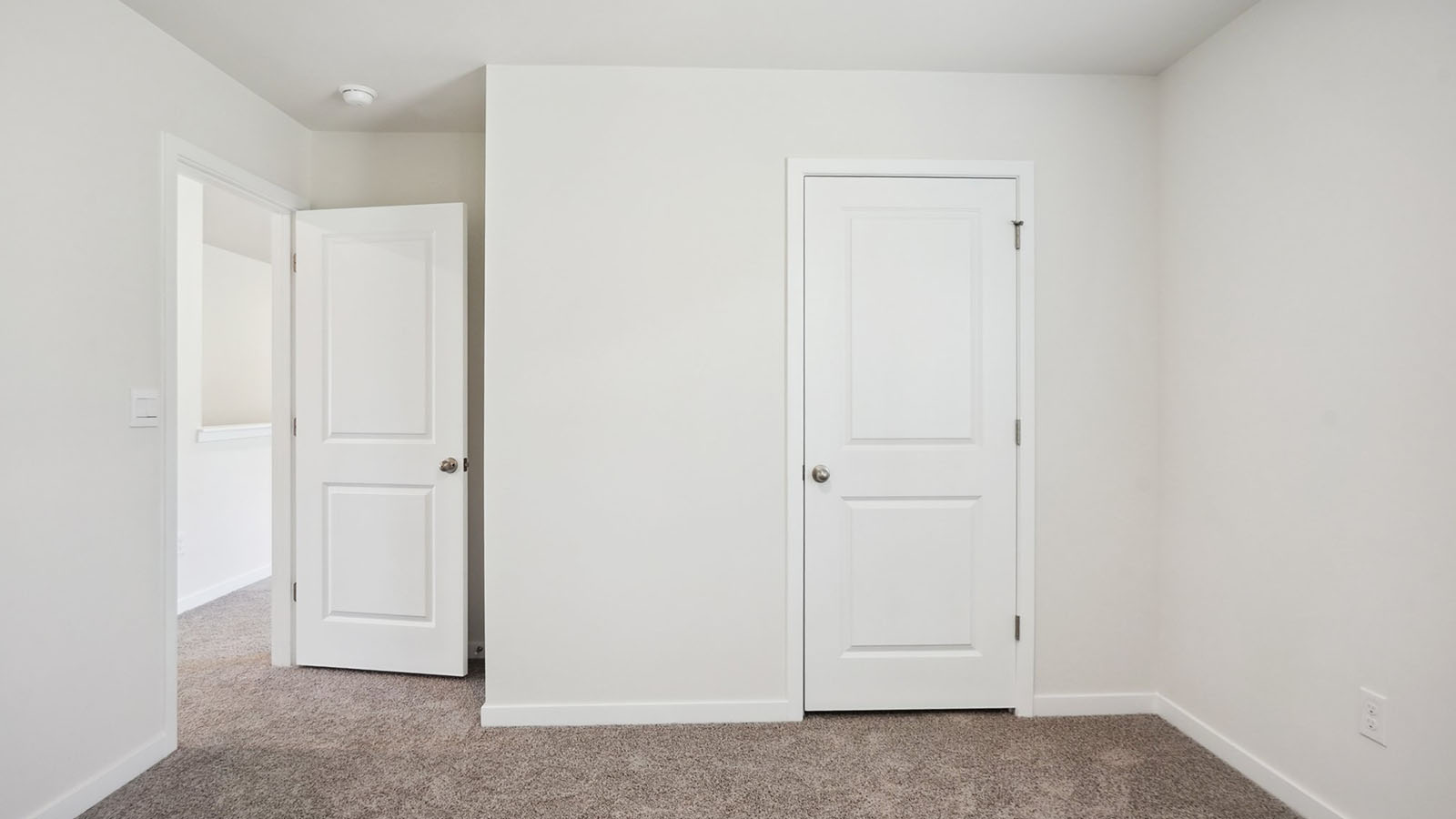 Model carpeted bedroom with small window