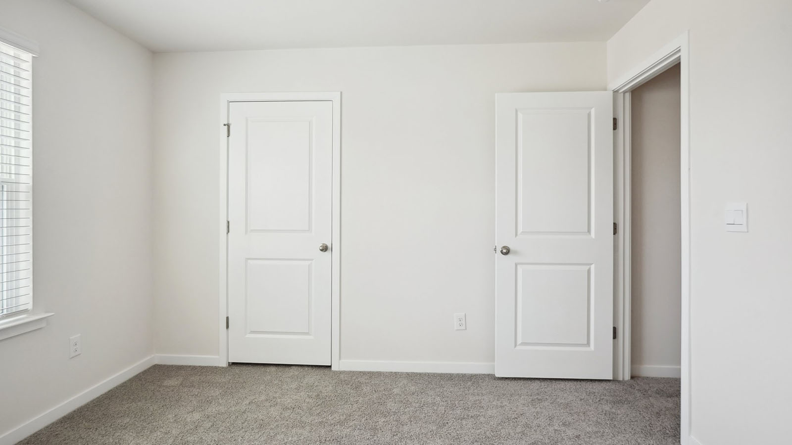 Model carpeted bedroom with small window