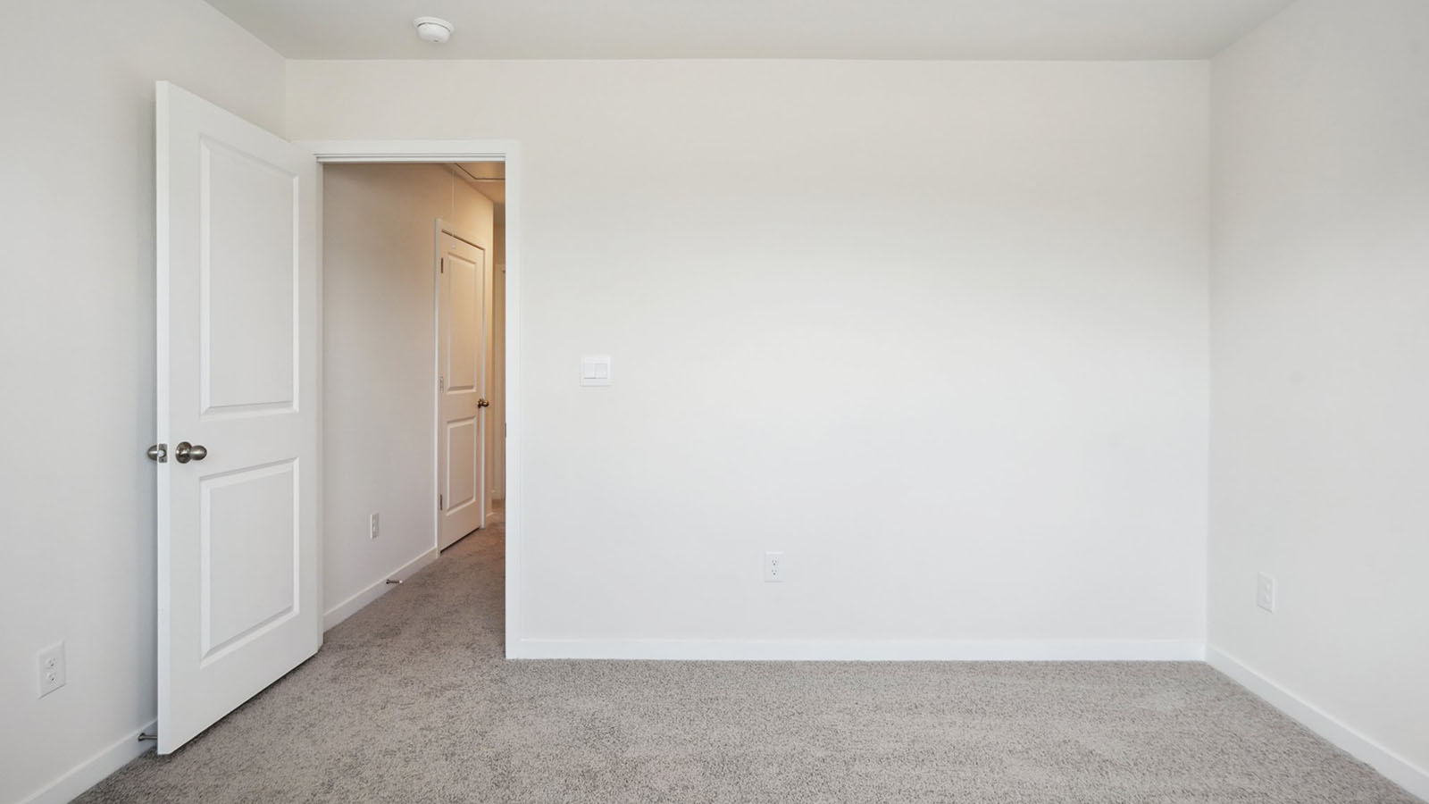 Model carpeted bedroom with small window