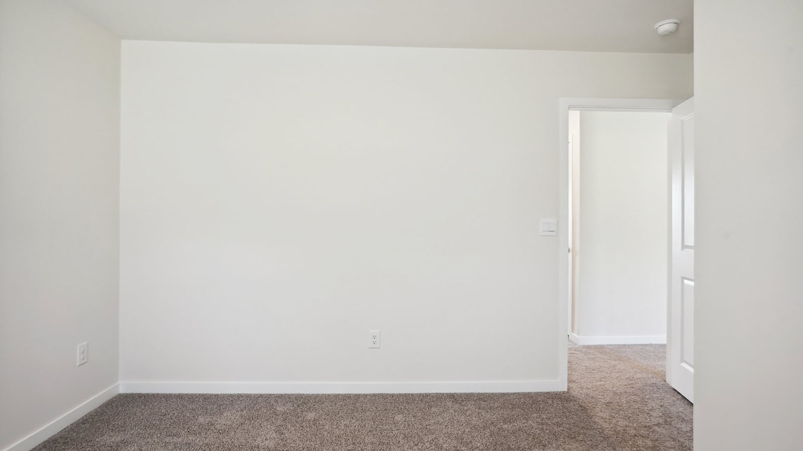 Model carpeted bedroom with small window