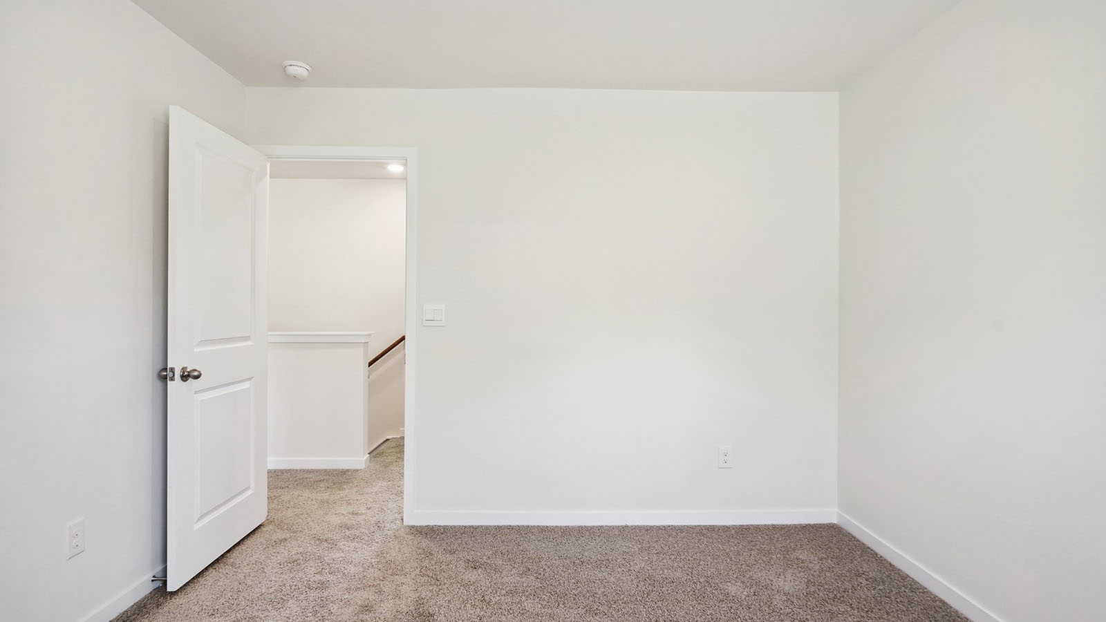 Model carpeted bedroom with small window