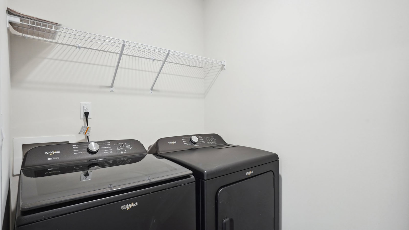 Model laundry room with rack above machines