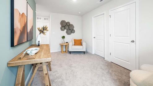 Carpeted loft space with large window