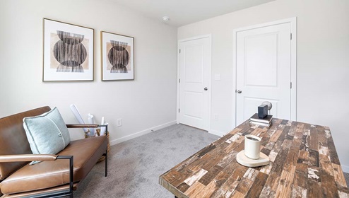 Carpeted bedroom used as an office with large window
