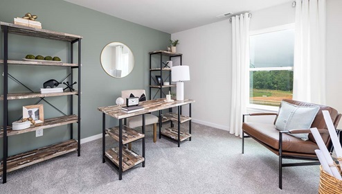 Carpeted bedroom used as an office with large window