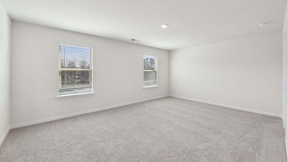 Carpeted bedroom with windows