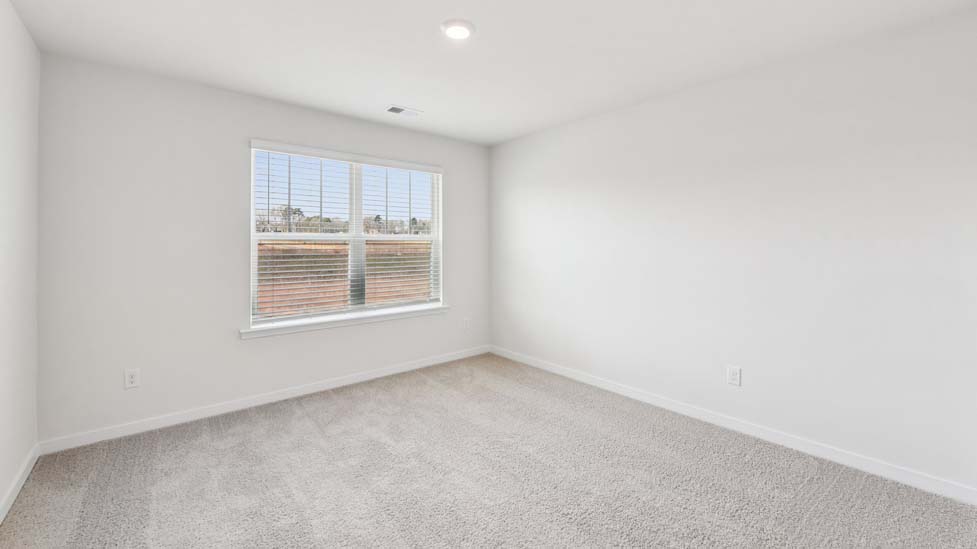 Carpeted bedroom with windows