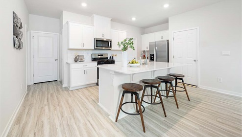 Kitchen and island with white cabinets and stainless steel appliances