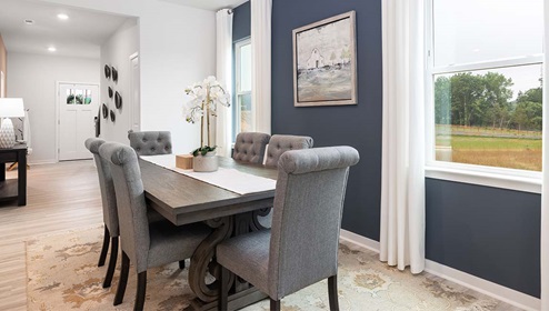 Dining area beside kitchen with large windows