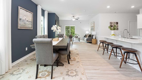 Dining area beside kitchen with large windows