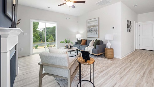 Living room area beside kitchen and dining with fireplace, ceiling fan, and sliding glass back doors