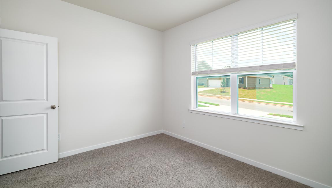 Carpeted bedroom with large window