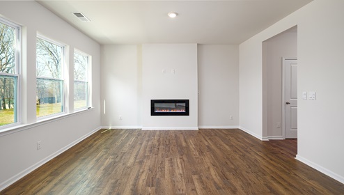 Living room space with wood floors, three large windows