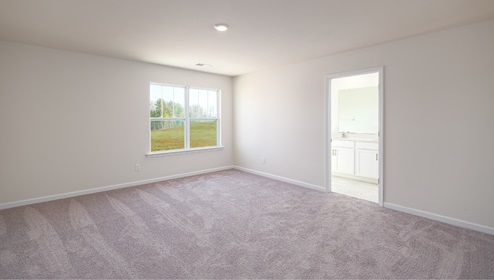 Carpeted bedroom with large window, view of bathroom door