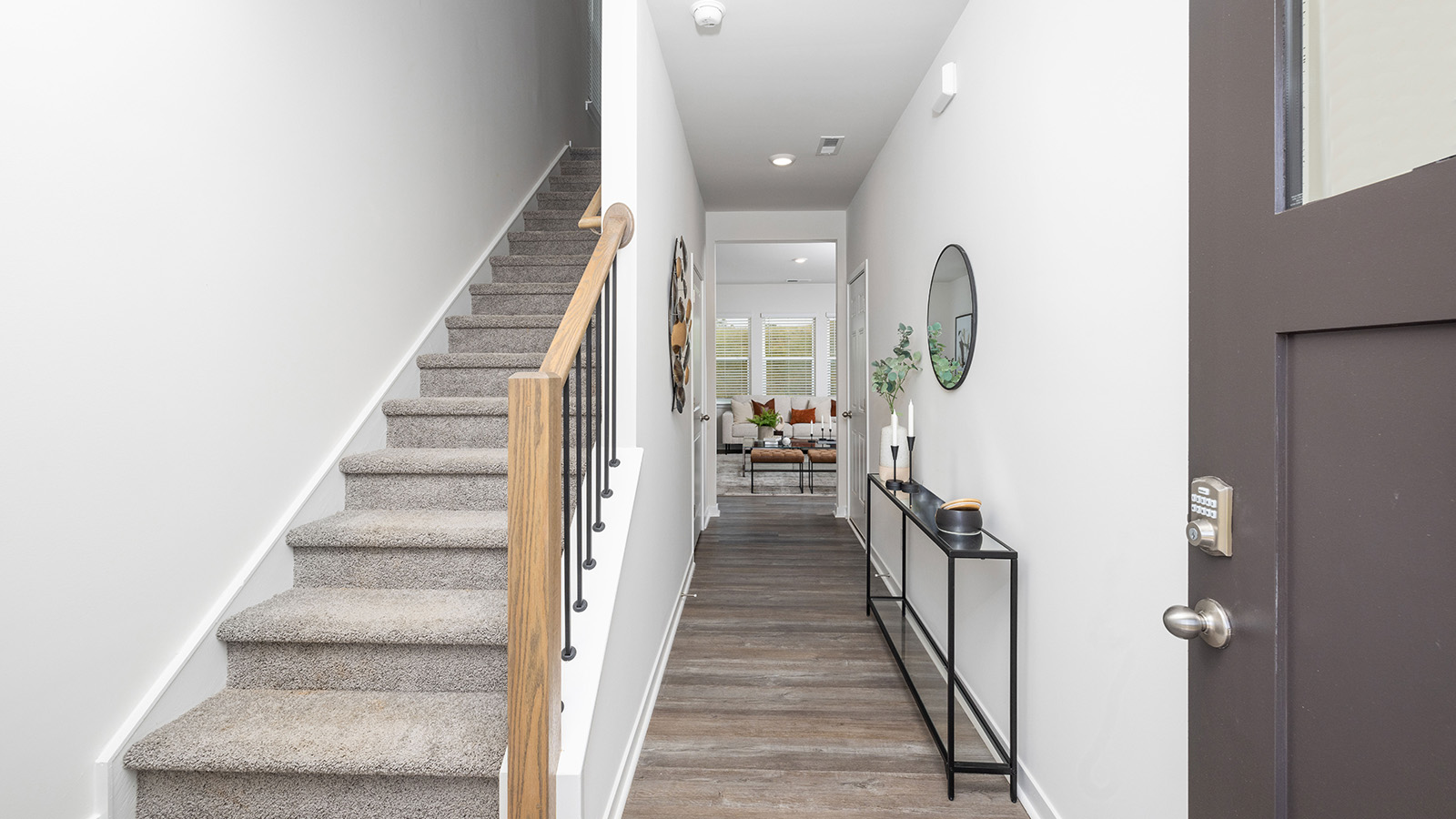 Welcoming foyer with wood floors, view of front door and stairs