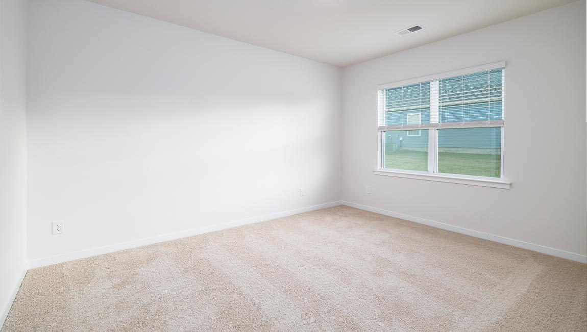 carpeted bedroom with large window