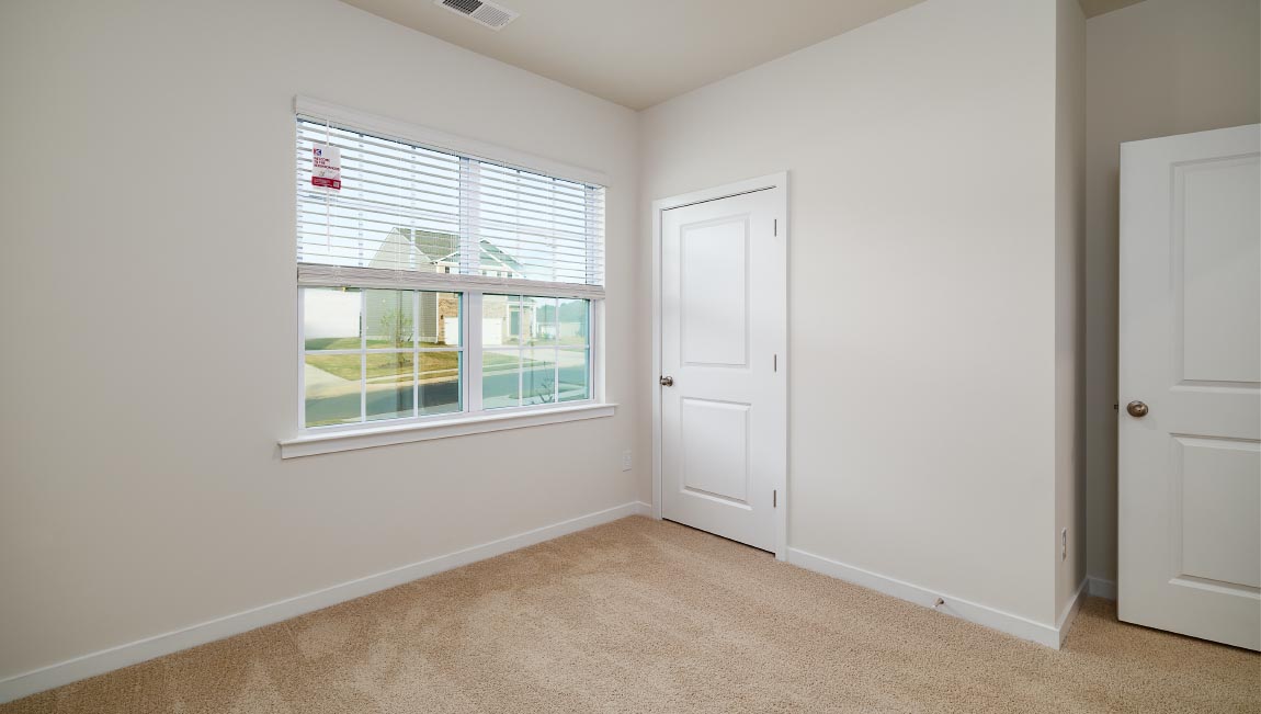 carpeted bedroom with large window