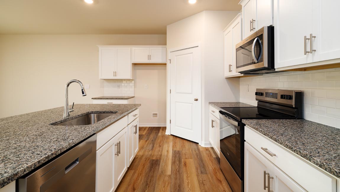 Kitchen and island with white cabinets and subway tiles and stainless steel subway tiles