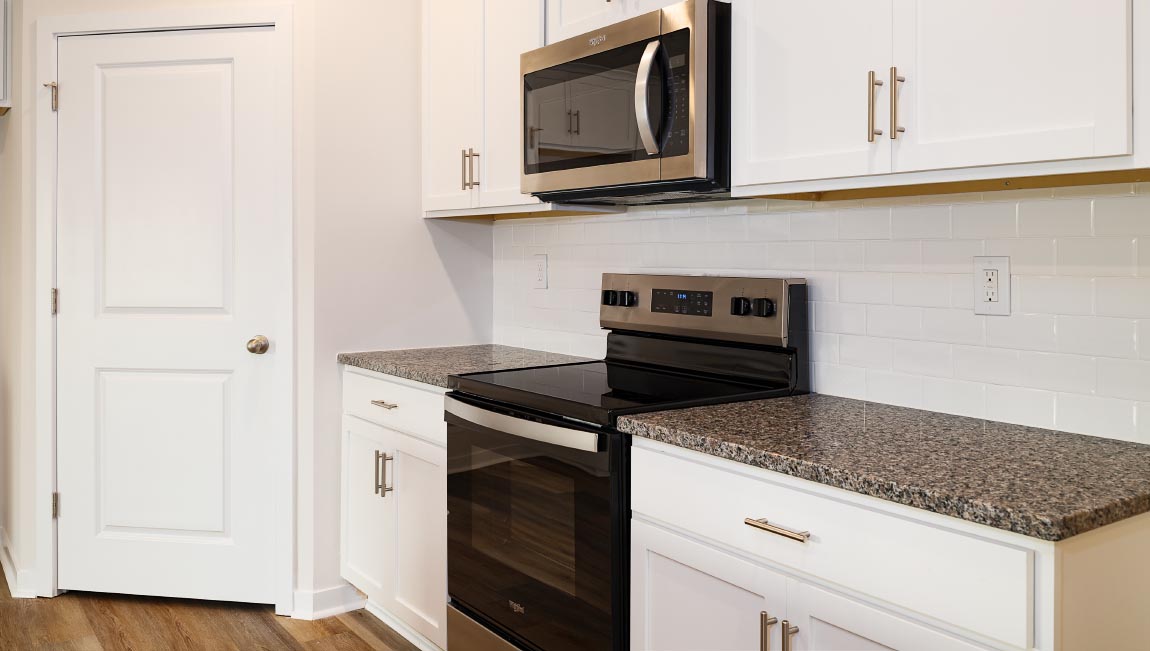 Kitchen and island with white cabinets and subway tiles and stainless steel subway tiles