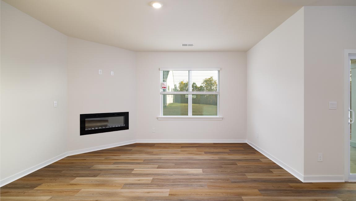 Open living room with wood floors, large window, and fireplace