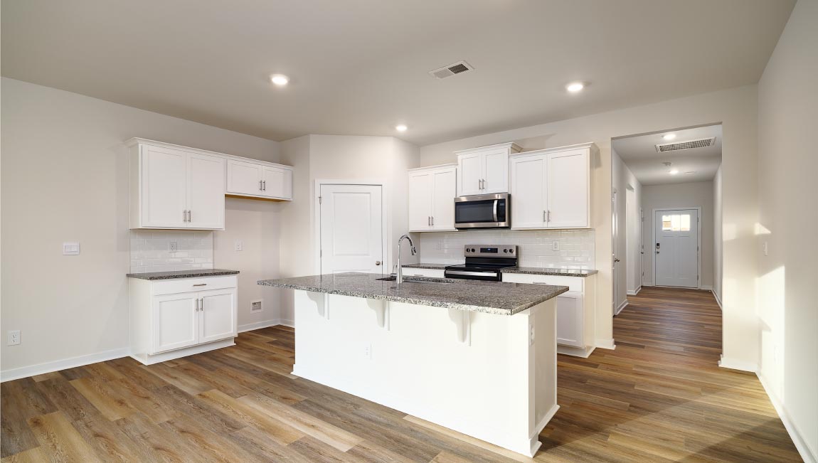 Kitchen and island with white cabinets and subway tiles and stainless steel subway tiles