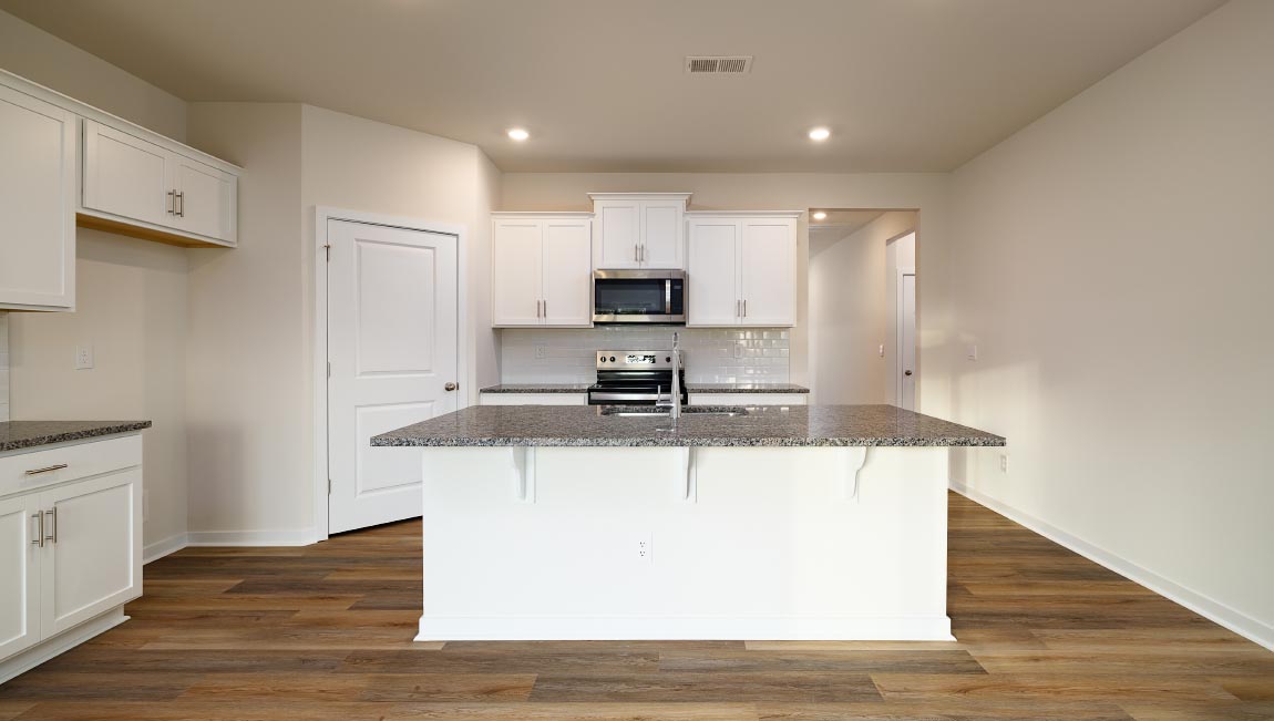 Kitchen and island with white cabinets and subway tiles and stainless steel subway tiles