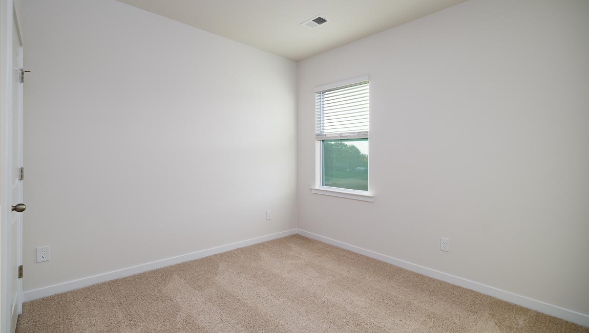 carpeted bedroom with large window