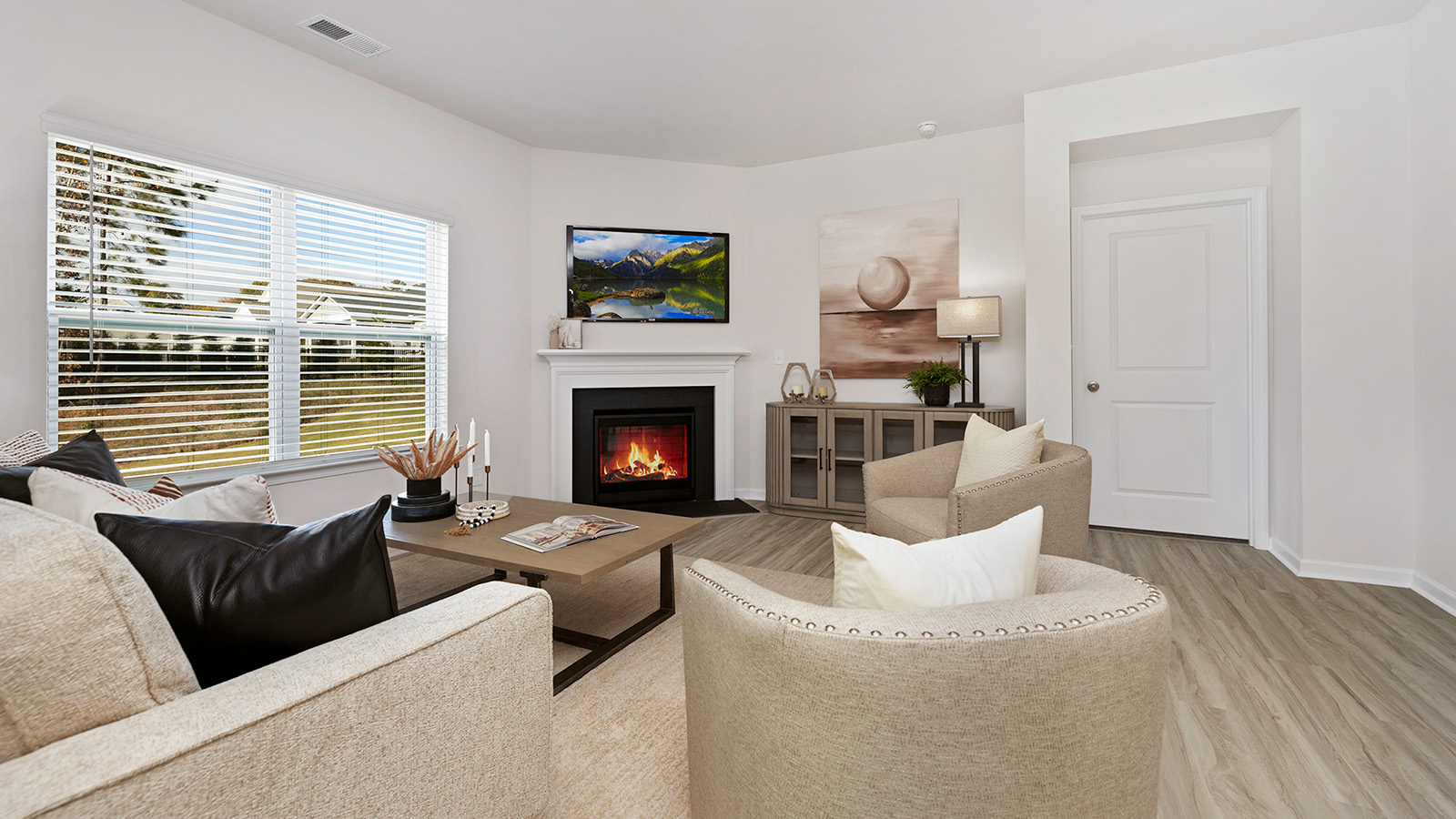 Open living room with wood floors, large window, and fireplace