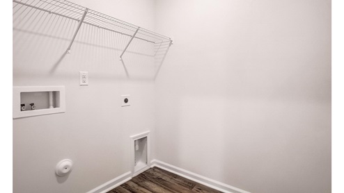 Laundry room with built in storage and hanging racks above machine space
