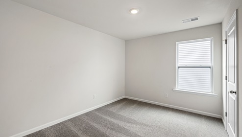 Carpeted bedroom with large window