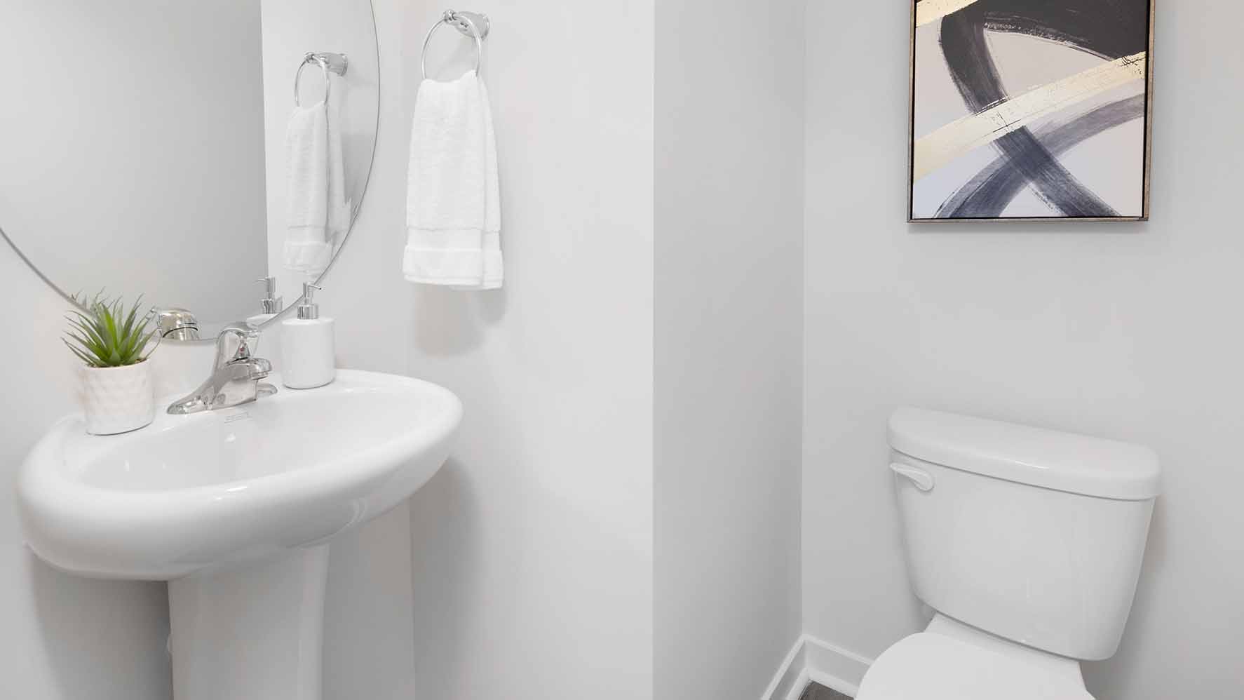 Bathroom with double sinks, white counters, cabinets and glass door shower