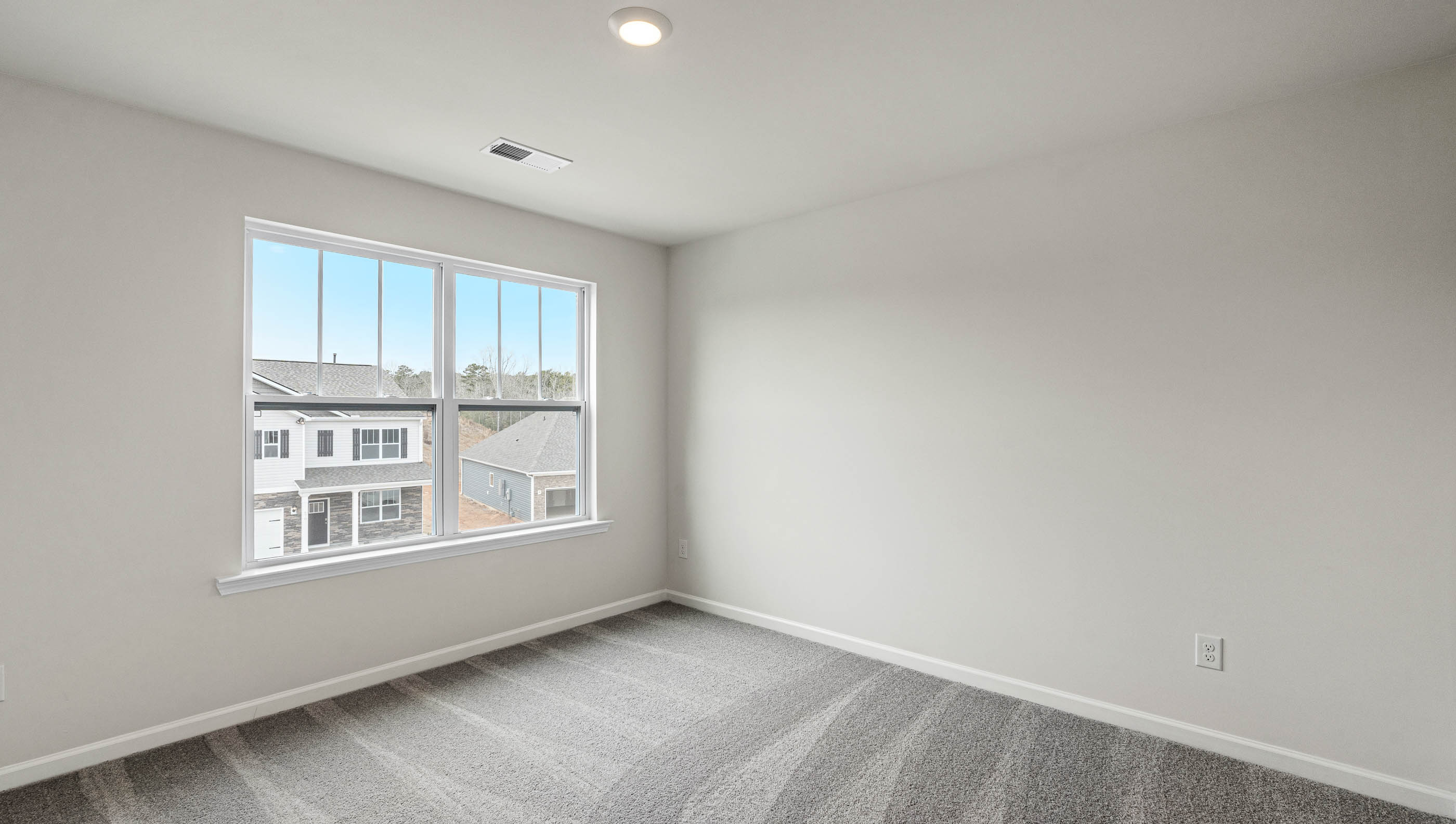 Carpeted bedroom with large window