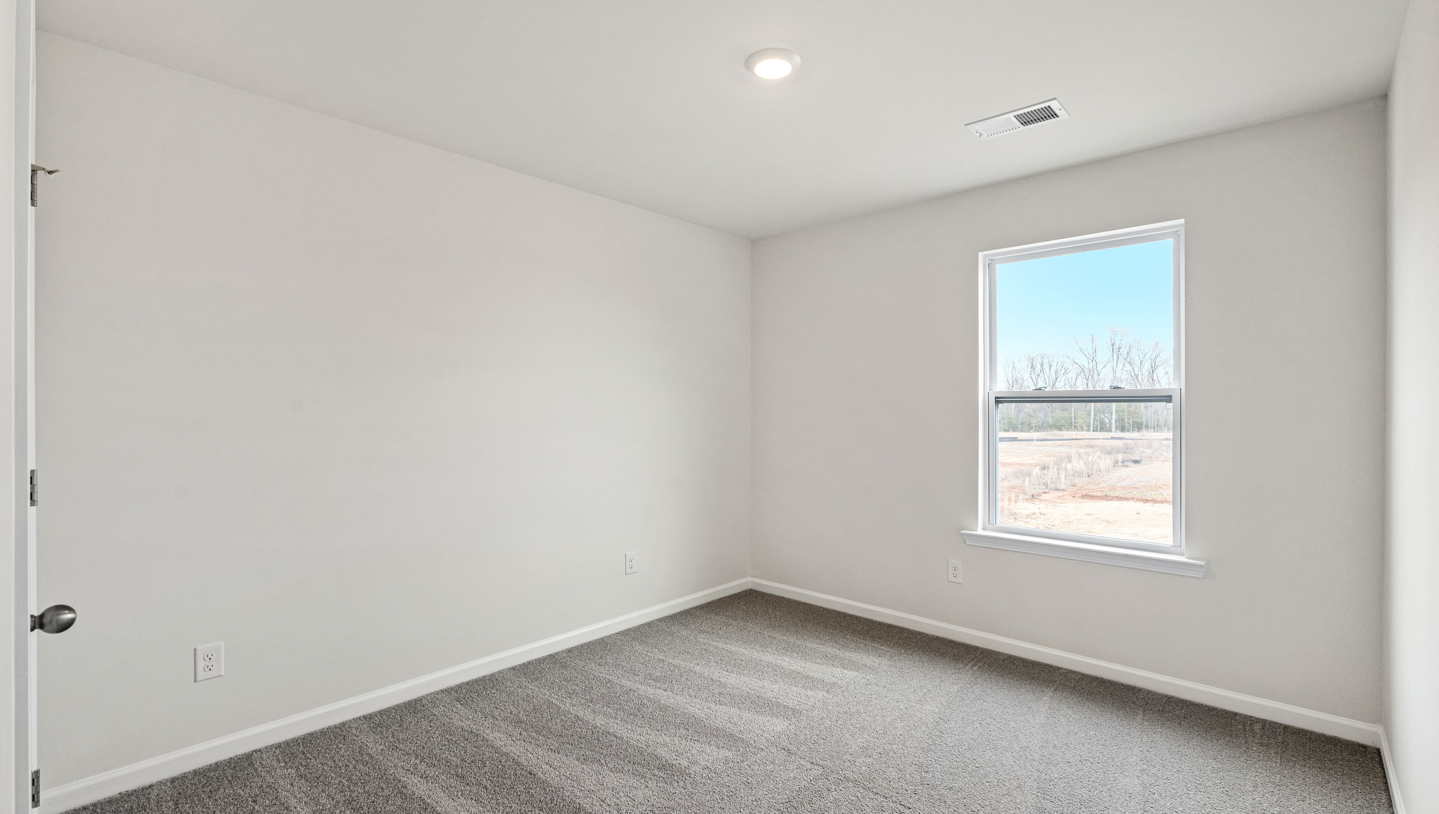 Carpeted bedroom with large window