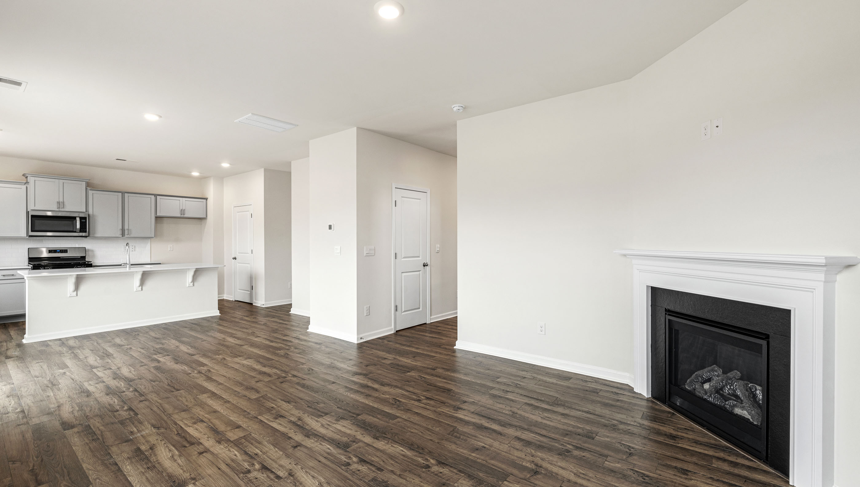 Living room with wood floors, fireplace and view of kitchen