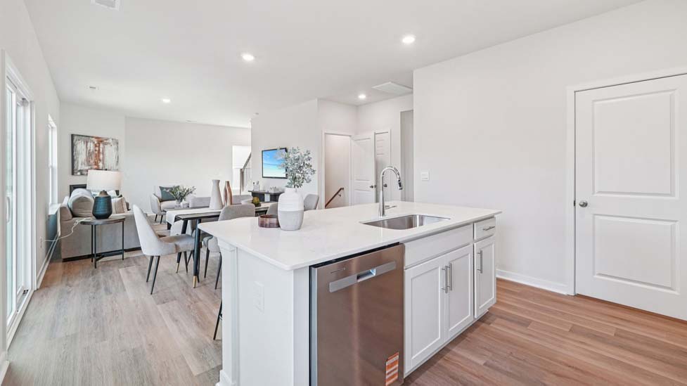Kitchen with island, white cabinets and wood floors