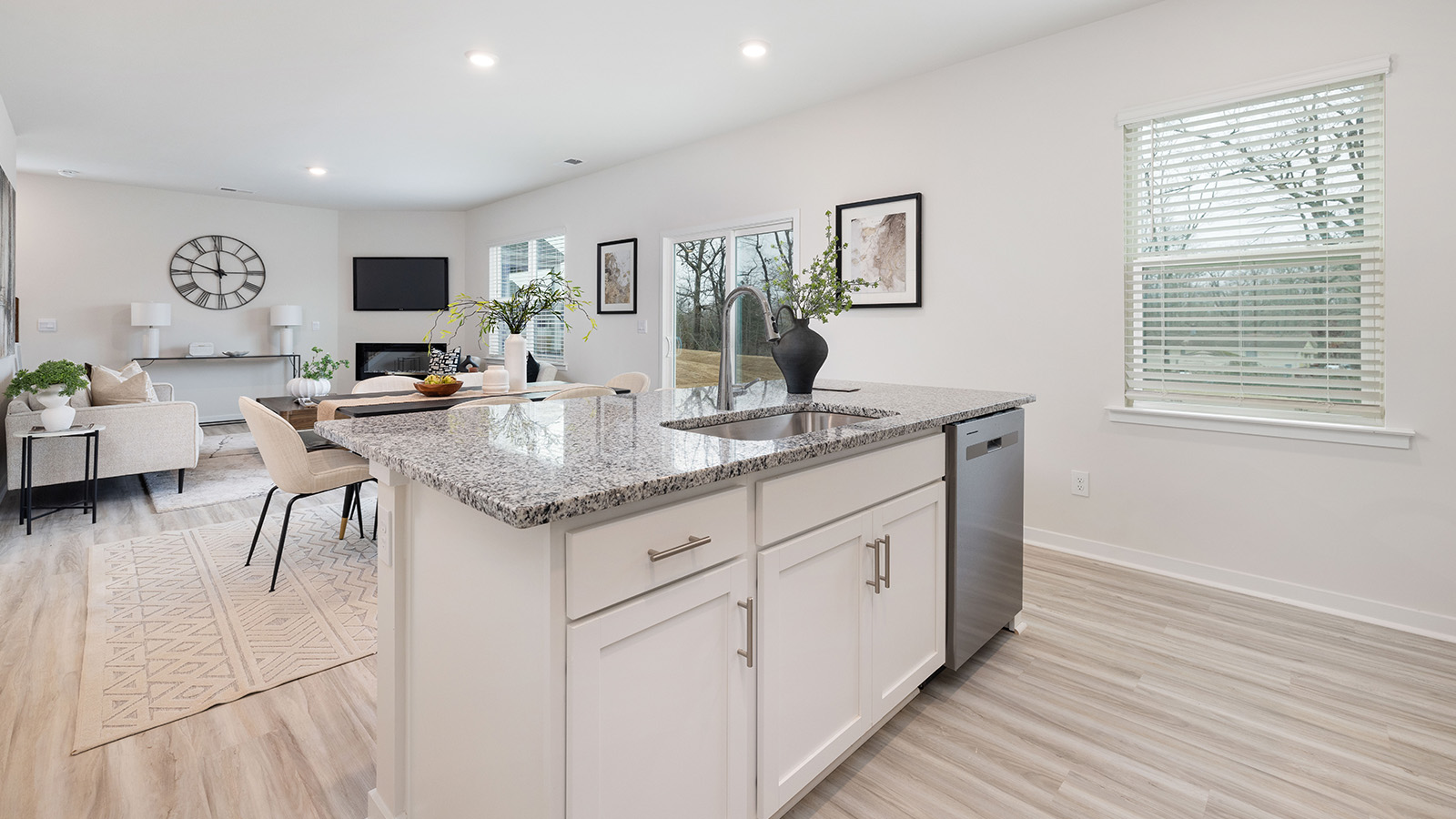 Kitchen with island, white cabinets and wood floors