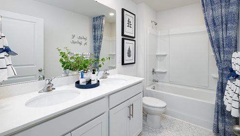 bathroom with white cabinets and counters, and bathtub