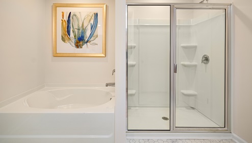 Primary bathroom with glass door shower, and bathtub