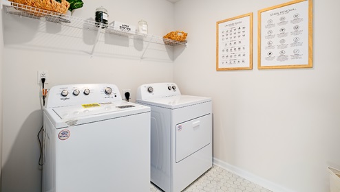 Laundry room with storage hanging racks above machines