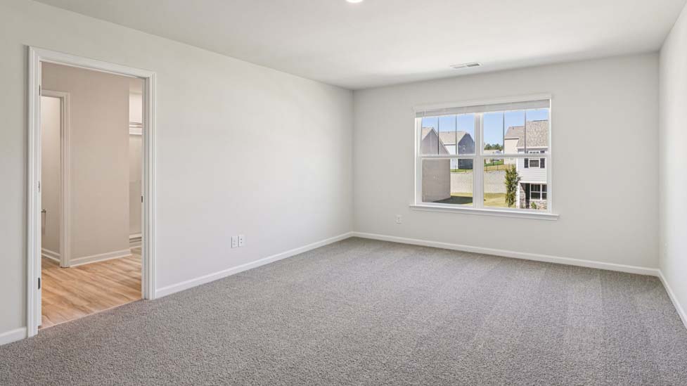 Carpeted bedroom with small window