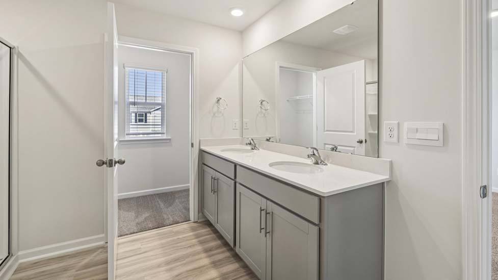 Primary bathroom with double sink vanity and large glass door shower