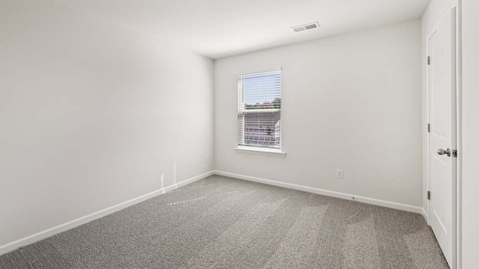 Carpeted bedroom with small window