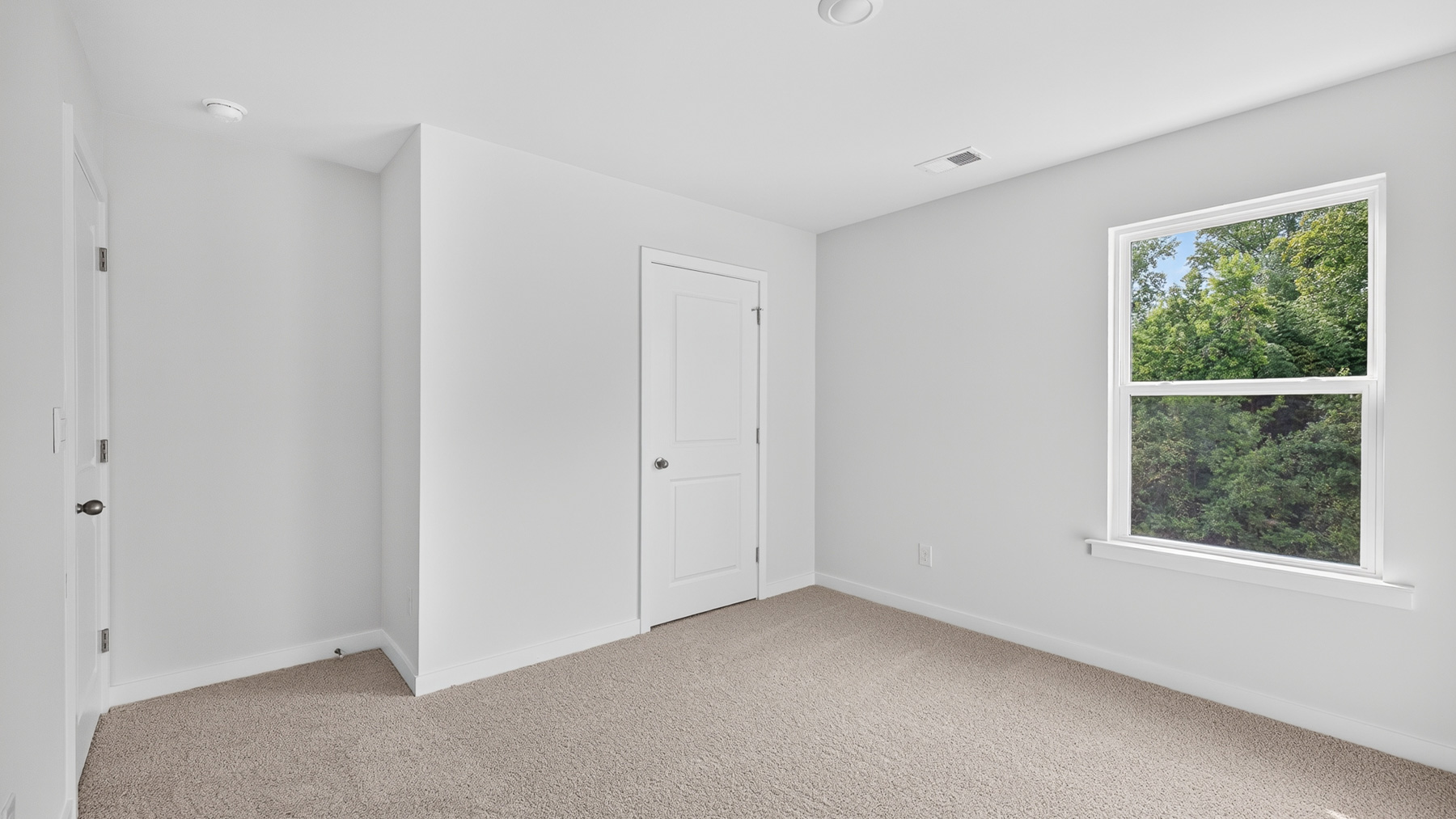 Carpeted bedroom with windows