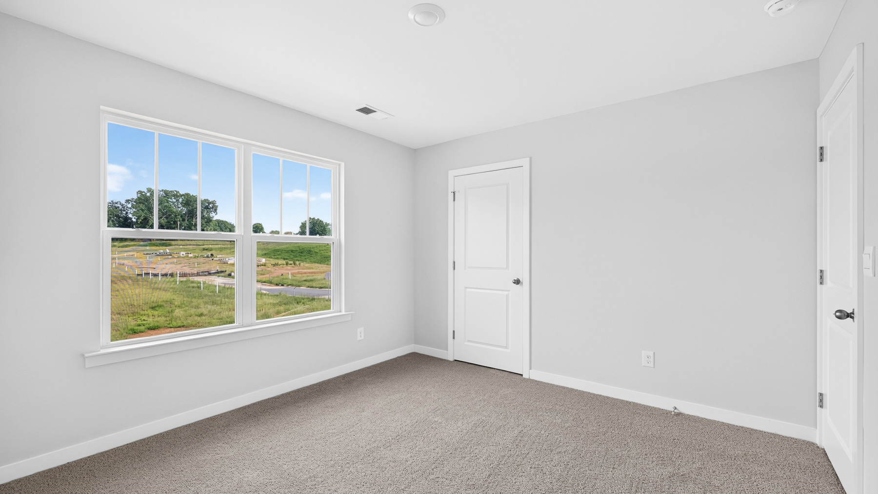 Carpeted bedroom with windows