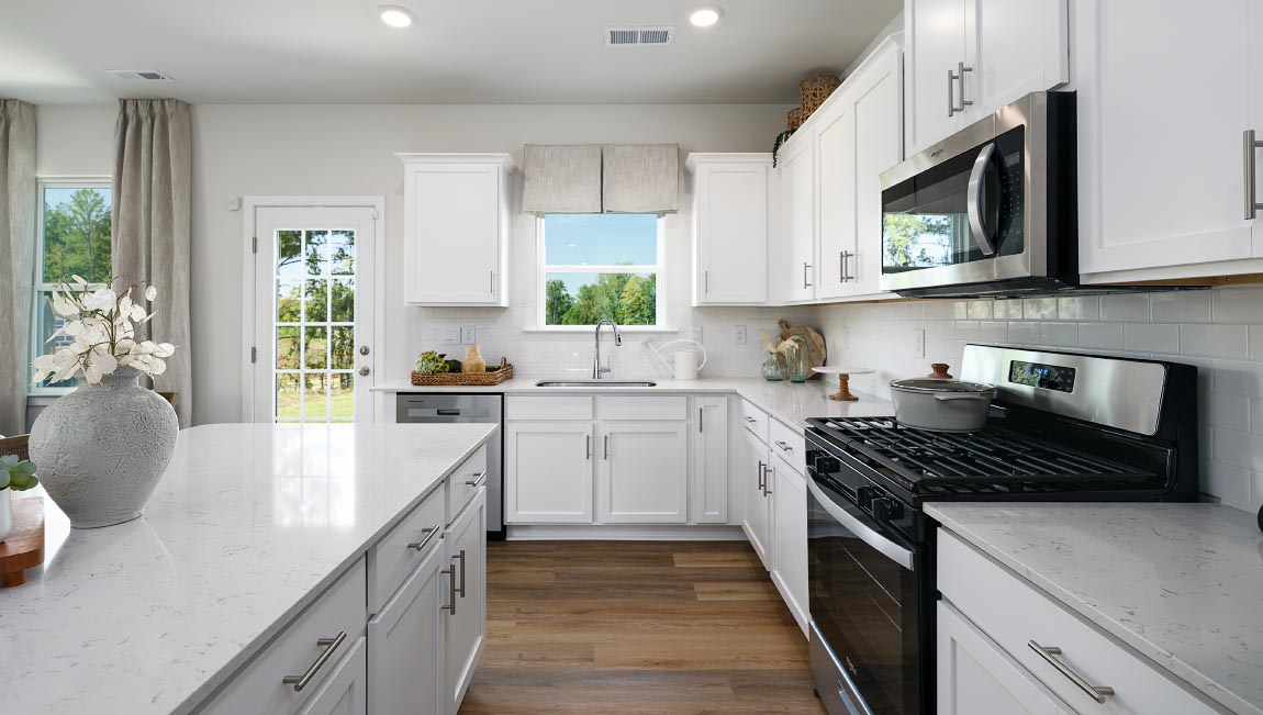 Kitchen and island with white counters and cabinets