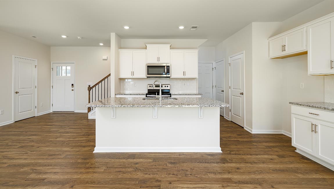 Kitchen and island, white cabinets, wood floors, and stainless steel appliances