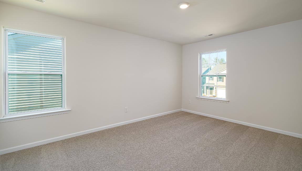 Primary bedroom, carpeted with large windows