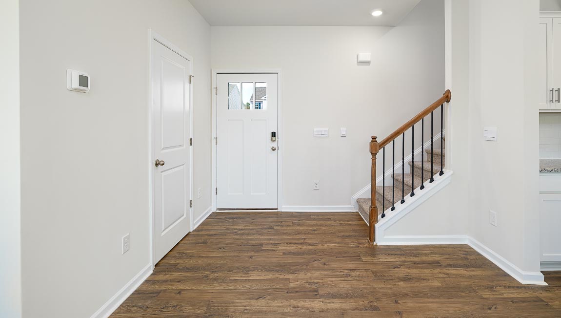 Welcoming foyer with view of front door and stairs