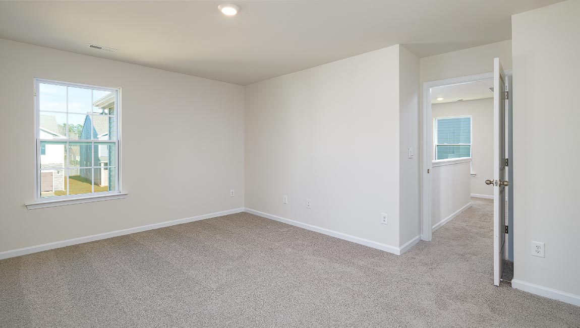 Primary bedroom, carpeted with large windows